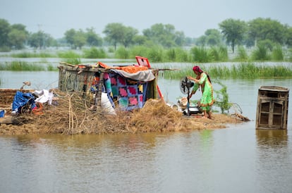 En la imagen, una mujer refugiada con sus pertenencias, después de las lluvias en Sohbatpur, el lunes.