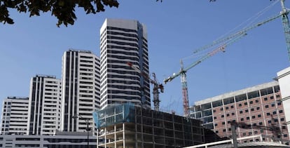 Un edificio en construcción junto a viviendas.