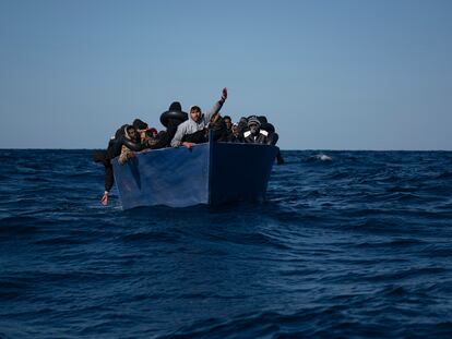 Un grupo de migrantes a bordo de una barca espera el rescate de la ONG española Open Arms en el Mediterráneo, en 2021.