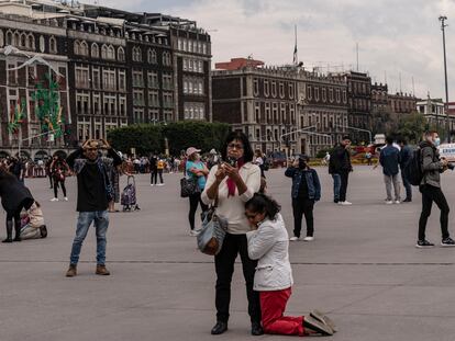 En el Zócalo, una mujer se arrodilla y recarga en otra luego del terremoto registrado el 19 de septiembre de 2022.