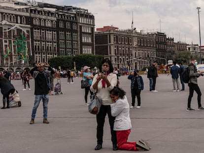 En el Zócalo, una mujer se arrodilla y recarga en otra luego del terremoto registrado el 19 de septiembre de 2022.