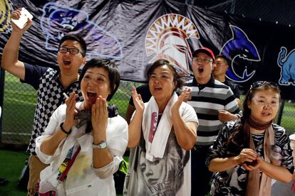 Amigos y familiares animan a los jugadores de fútbol americano en China.