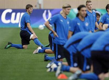Arshavin estira durante el entrenamiento de ayer con el resto de sus compañeros en primer término.