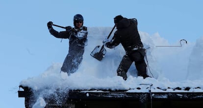 Miembros del ejército austríaco quitan nieve de un tejado en Werfenweng.