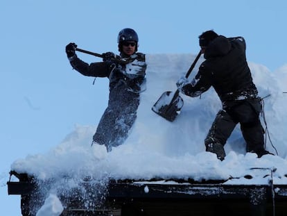 Miembros del ejército austríaco quitan nieve de un tejado en Werfenweng.