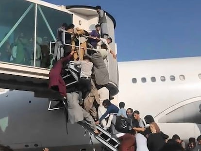 Afegãos tentam aceder a um avião no aeroporto de Kabul, nesta segunda-feira.