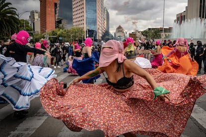 Mujeres del colectivo 'Capuchas Rosas' acompañan la marcha con música y baile, retratadas frente a la fuente del Caballito.