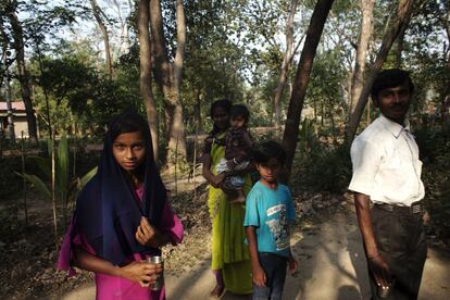 Amisha (a la izquierda), de 13 años, pasea por los caminos de Shodhgram con su hermano y su padre.