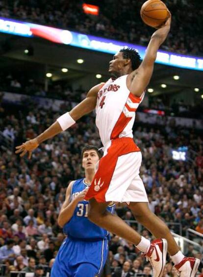 El jugador de los Raptors Chris Bosh machaca el aro ante la mirada del ala-pívot de los Magic Darko Milicic.