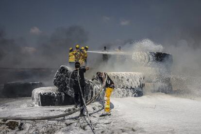 Bomberos israelíes extinguen el fuego de los neumáticos quemados por los manifestantes palestinos en la Franja de Gaza. 