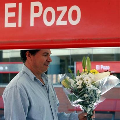 Un hombre porta un ramo de flores en el barrio madrileño de El Pozo, donde varios cientos de personas han recordado hoy, en silencio, a las víctimas de los atentados. 68 de ellas murieron en esa estación de tren.