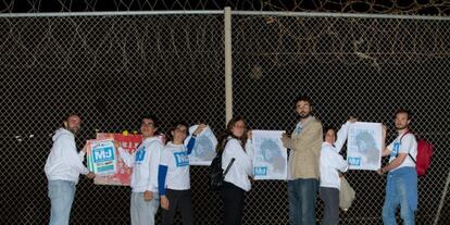 Miembros de PUM+J, integrantes de la coalición Primavera Europea, durante la pegada de carteles en la valla.