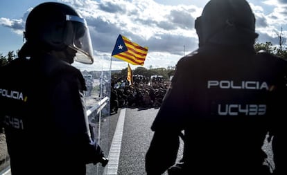 Dos antidisturbios de la Policía Nacional, este miércoles, frente a una masa de manifestantes en la autopista AP-7.