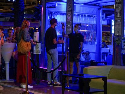 Un empleado toma la temperatura a un joven en la entrada de un pub de Marbella.