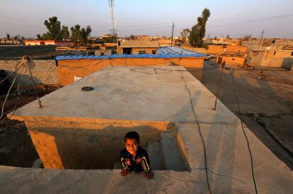 Un niño kurdo de la minoría Kakai juega en el techo de una casa en su pueblo situado cerca de la ciudad de Kalak, al este de Mosul (Irak).