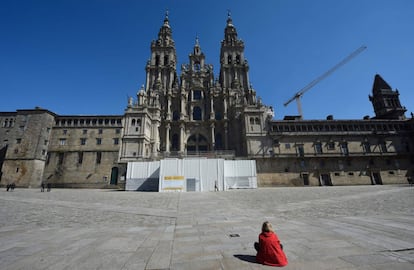 No hay peregrinos en la plaza del Obradoiro. La epidemia ha provocado un alto en el camino. Solo una mujer contempla en soledad la Catedral de Santiago. Imagen tomada el 14 de marzo.