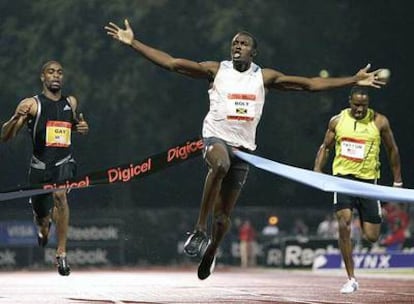 Usain Bolt cruza la meta por delante de Tyson Gay (a la izquierda) en la madrugada de ayer.