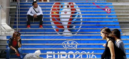 Dos j&oacute;venes pasan ante las gradas de uno de los estadios que acoger&aacute;n la Eurocopa.