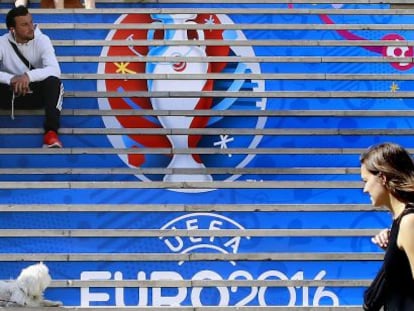 Dos j&oacute;venes pasan ante las gradas de uno de los estadios que acoger&aacute;n la Eurocopa.