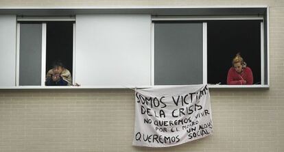 Dos mujeres asomadas a las ventanas de uno de los pisos ocupados.