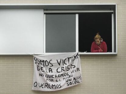 Dos mujeres asomadas a las ventanas de uno de los pisos ocupados.