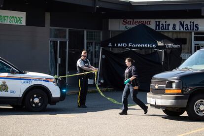 Un agente precinta la zona en la que ha tenido lugar un tiroteo, este lunes en Langley (Canadá).