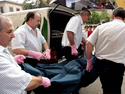 Trabajadores de la funeraria de Palma de Mallorca trasladan el cuerpo de la mujer encontrada muerta junto a sus dos hijas.