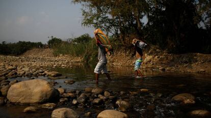 Un par de venezolanos cruzan el río de Táchira, en la frontera entre Colombia y Venezuela.