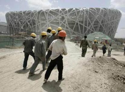 Un grupo de trabajadores junto al Estadio Nacional Olímpico, el <i>Bird's Nest</i>, que se está construyendo en Pekín.