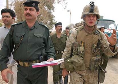 Un <b><i>marine</b></i> acompaña a un policía iraquí en una patrulla conjunta a las afueras de un hospital de Bagdad.