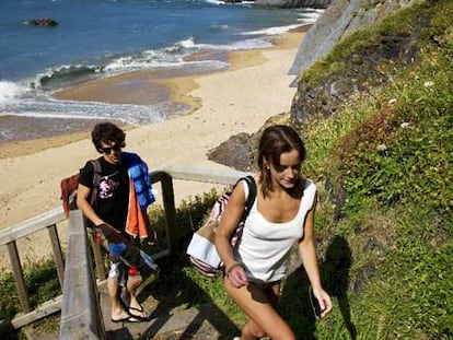 Dos jóvenes bañistas regresan tras una jornada en la playa de Picón.
