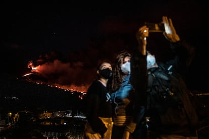 Tres personas se hacen una foto con el volcán al fondo, en el mirador de Tajuya (La Palma). 