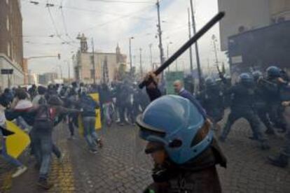 Un grupo de estudiantes se enfrenta a varios agentes antidisturbios durante manifestación en Nápoles (Italia) hoy, viernes 15 de noviembre de 2013. Multitudinarios grupos de estudiantes se han lanzado a las calles en todo el país para protestar en contra de las medidas de austeridad y recortes en educación del Gobierno, planeados en los presupuestos de 2014.