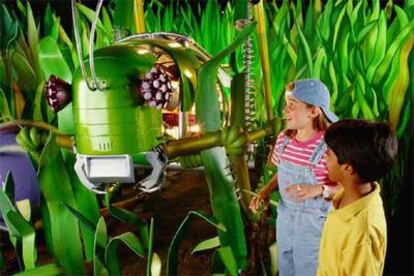 Unos niños se divierten con el enorme saltamontes del Zoo de los Robots. Arriba a la derecha, la jirafa mecánica.