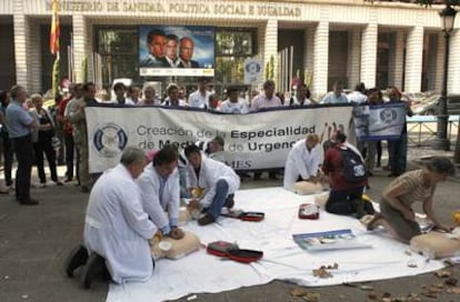 Médicos de urgencias y emergencias, durante la concentración que protagonizaron ante la sede del Ministerio de Sanidad para pedir una especialidad primaria, troncal y vía MIR, hoy en Madrid.