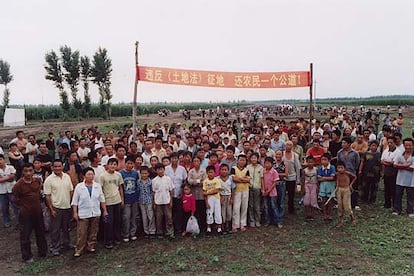 Habitantes de Qianjin, ante la pancarta de protesta por la construcción de una autopista.