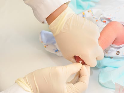 Un sanitario practica la prueba del talón a un bebé.