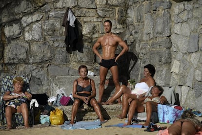 Un grupo de personas toma el sol en la playa de San Lorenzo, en Gijón.