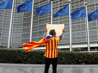 Un independentista con una estelada muestra un cartel frente a la sede de la Comisión Europea en Bruselas.