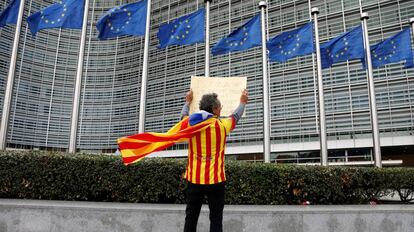 Un independentista con una estelada muestra un cartel frente a la sede de la Comisión Europea en Bruselas.