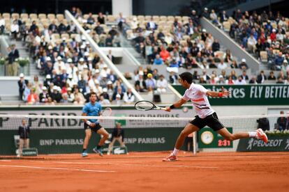 Novak Djokovic, en primer plano, devuelve la bola a Dominic Thiem.