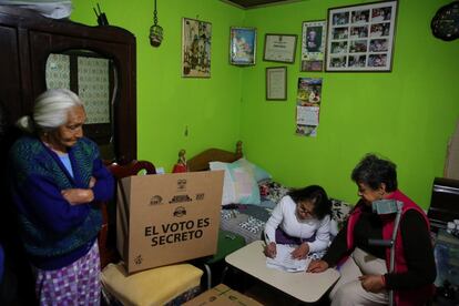 Una mujer firma un documento después de votar mediante un programa que permite a gente con incapacidad votar por adelantado para las elecciones presidenciales, en Quito, Ecuador.
