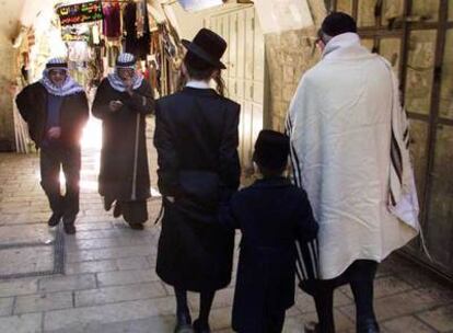 En un mercado de Jerusalén,  tres judíos (en primer plano) y dos musulmanes, en 2001.	R