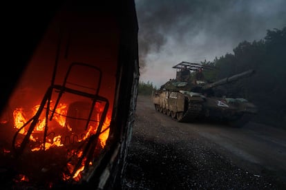 Un tanque ucraniano pasa delante de un coche en llamas, el miñercoles en la provincia de Sumi, muy cerca de la región rusa de Kursk.