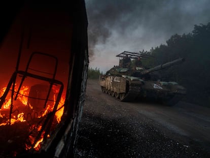 Un tanque ucraniano pasa delante de un coche en llamas, el miñercoles en la provincia de Sumi, muy cerca de la región rusa de Kursk.