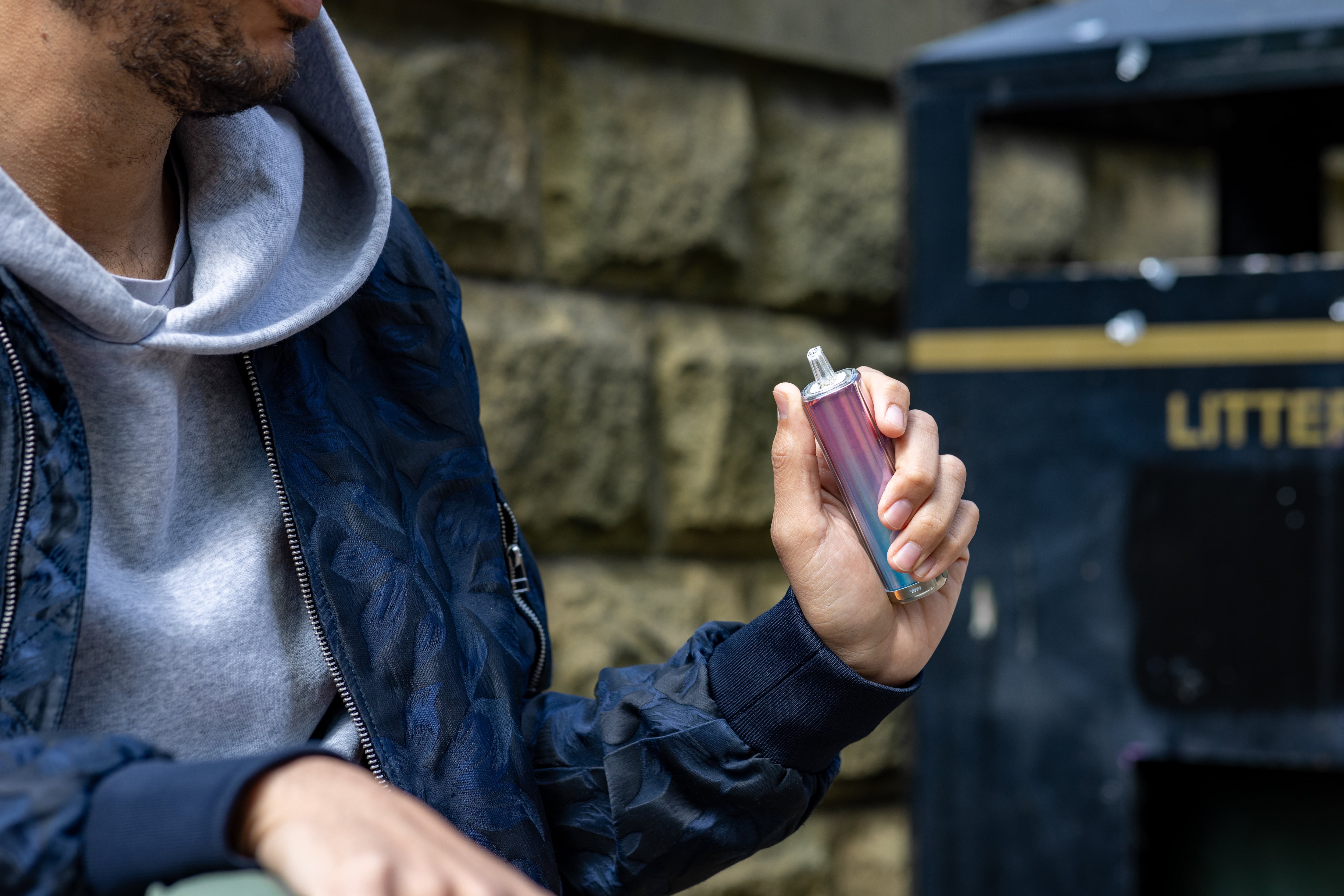 Un hombre con un cigarrillo electrónico desechable en la mano.