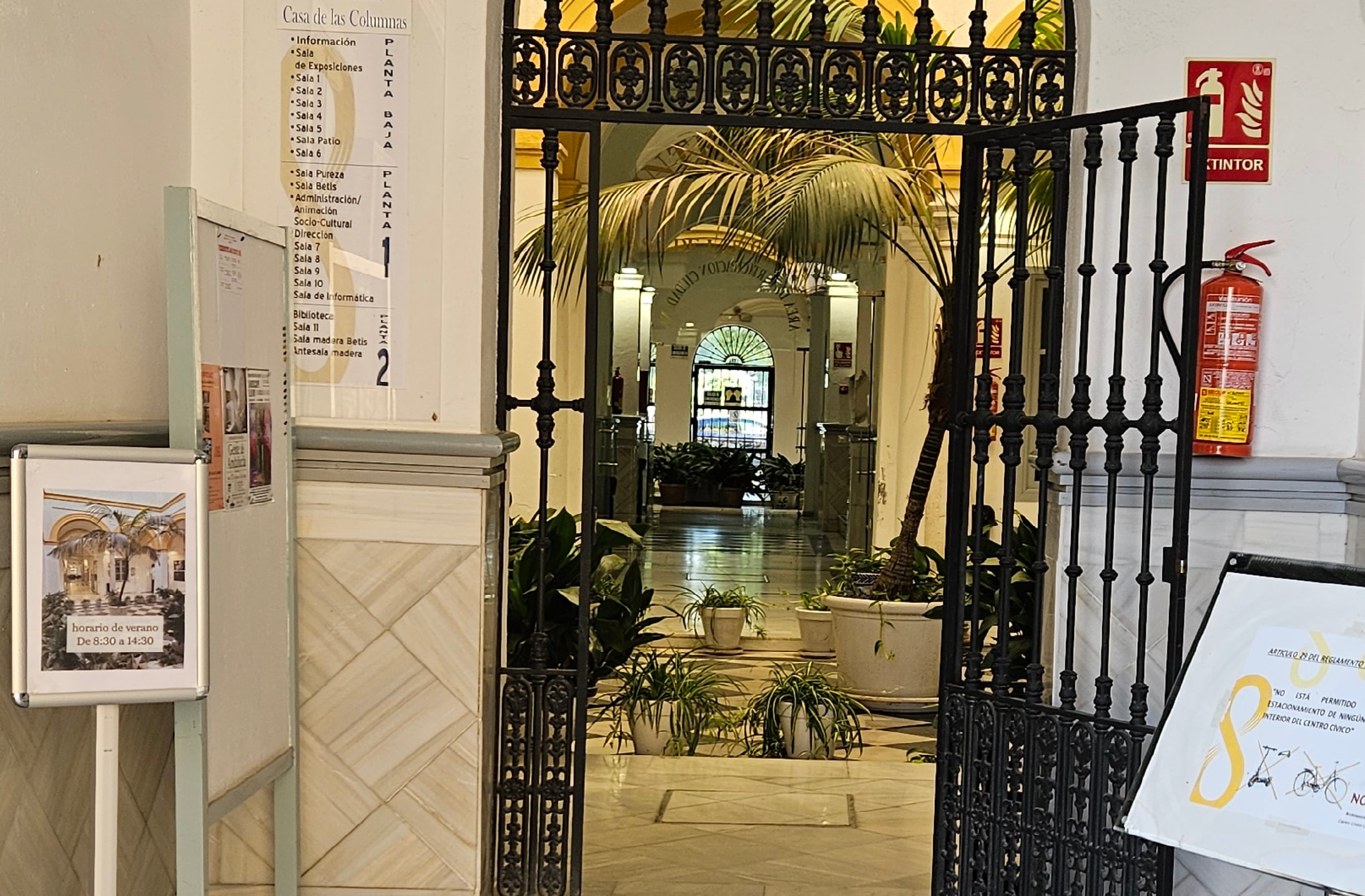 El centro Las Columnas de Sevilla, de acceso gratuito y potencial refugio climático municipal, muestra a la entrada el horario de verano: de 8.30 a 14.30.