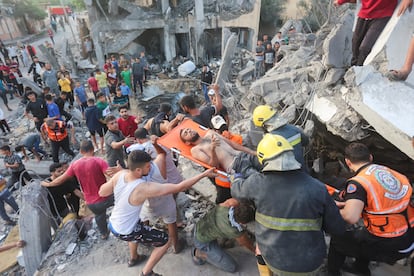 Los equipos de rescate lograban extraer de entre los escombros de un edificio derrumbado por un bombardeo israelí a un hombre, este martes en Jan Yunis. 
