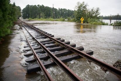 Aguas de la inundación dañan las vías del tren y cubren una carretera en Wallace, Carolina del Sur.