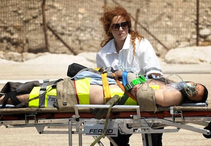 Un enfermero israelí traslada a uno de los heridos llegados en helicóptero al puerto de Haifa.